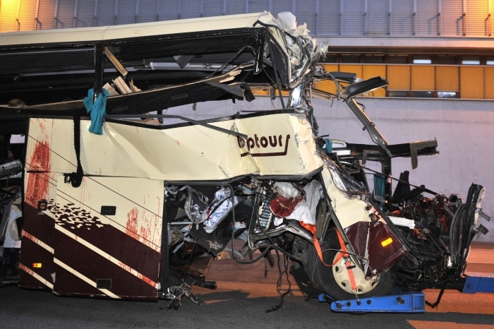 Autocarul implicat în accidentul rutier din Elveţia este tractat de la locul accidentului, 13 martie 2012. Cel puţin 28 de persoane, dintre care 22 de copii, şi-au pierdut viaţa într-un accident de autocar în Elveţia. (SEBASTIEN FEVAL/AFP/Getty Images)