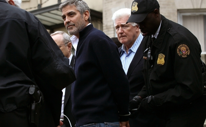 WASHINGTON, DC - 16 martie 2012:  Actorul George Clooney (stânga) este arestat alături de tatăl său, Nick Clooney (dreapta) în timpul unei demonstraţii în faţa Ambasadei din Sudan. O serie de organizaţii, printre care şi Amnesty International, au organizat un raliu pentru a cere Statelor Unite şi liderilor lumii să înceteze violenţa din sudul Sudanului, prevenindu-se astfel ca mii de oameni să moară de foame.