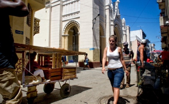Cubanezi trec pe lângă biserica Our Lady of Charity, ocupată de 13 cubanezi, pe 14 martie 2012 în Havana.