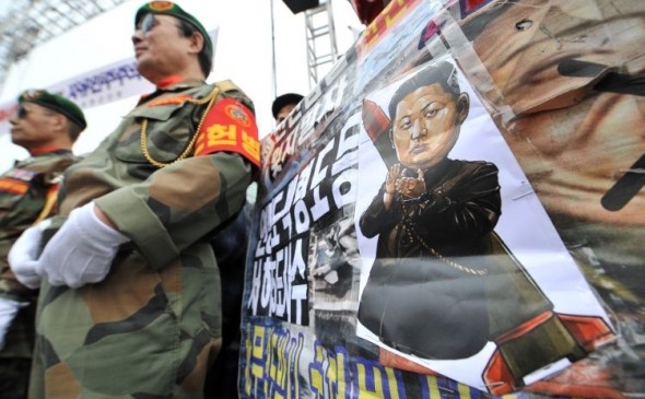Veterani de război sud-coreeni lângă o plancardă înfăţişând o caricatură a "preaiubitului conducător" Kim Jong-Un, în timpul unui miting împotriva Coreei de Nord, care a marcat scufundarea navei de război Cheonan de către nordul comunist. (Jung Yeon-Je / AFP / Getty Images)