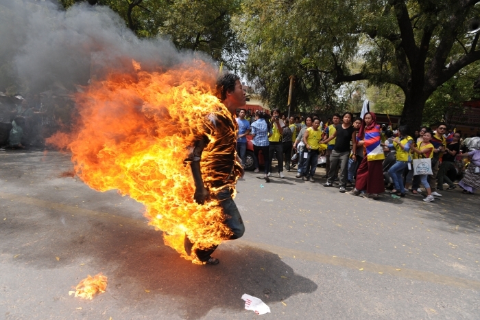 Exilatul tibetan, Jampa Yeshi, 27 de ani, aleargă înconjurat de flăcări  înaintea vizitei preşedintelui Chinei, Hu Jingtao, în capitala îndiei,  New Delhi, pe 26 martie 2012.