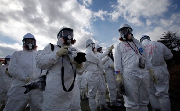 Oficiali ai companiei Tokyo Electric Power Co. (TEPCO) şi membri mass media privesc rămăşiţele uzinei nucleare Fukushima Daiichi, 20 februarie 2012 (Issei Kato / AFP / Getty Images)