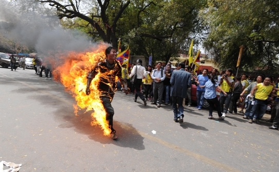 Exilatul tibetan, Jampa Yeshi, 27 de ani, aleargă înconjurat de flăcări înaintea vizitei preşedintelui Chinei, Hu Jingtao, în capitala îndiei, New Delhi, pe 26 martie 2012. (STRDEL / AFP / Getty Images)
