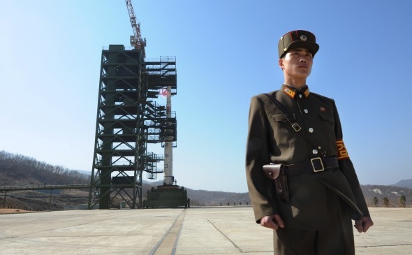Soldat nord-coreean stând de pază în faţa unei rachete Unha-3 la centrul spaţial Tangachai -ri, 8 aprilie 2012
