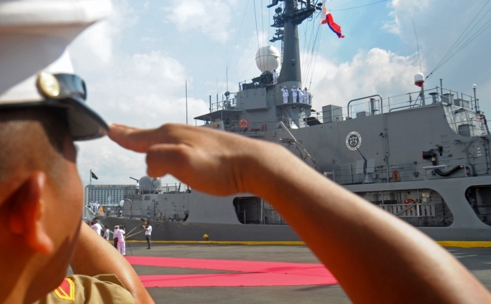 Un soldat marinar filipinez salută arborarea steagului pe nava amiral Gregorio Del Pilar.