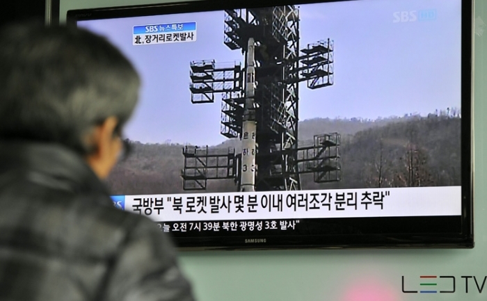 Sud-coreenii opriţi într-o staţie de tren, în Seul, pentru a viziona un raport TV despre lansarea de rachete din Coreea de Nord, pe 13 aprilie, 2012