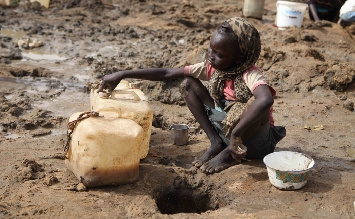 O fată scoate apă dintr-o gaură în pământ, 22 martie 2012 în Jamam, Sudanul de Sudâ (HANNAH MCNEISH / AFP / Getty Images)