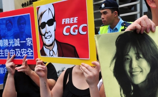 Demonstranţi cu bannere îl sprijină pe militantul orb Chen Guangcheng şi pe activistul pentru drepturile omului He Peirong, care l-a ajutat pe Chen să evadeze pe 22 aprilie din casa sa din satul Dongshigu, în timpul unui protest în Hong Kong