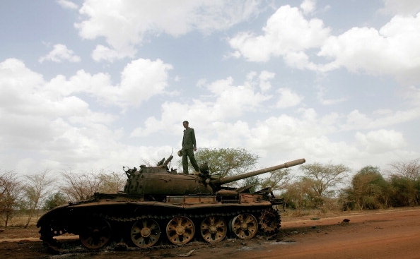 Un soldat sudanez stând pe un tanc distrus al Armatei de Eliberare a Poporului Sudanez, din Sudanul de Sud.