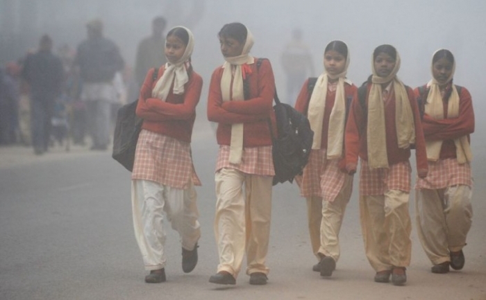 Eleve din India merg la şcoală, în timpul unei dimineţi ceţoase şi reci la New Delhi la 20 ianuarie, 2012.