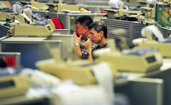 Brokerii de la bursa de acţiuni din Hong Kong, 7 mai 2012 (Laurent Fievet / AFP / Getty Images)