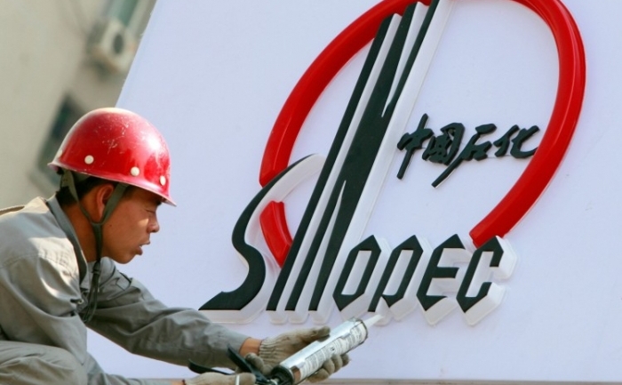 Un muncitor instalează un logo Sinopec, la o nouă staţie Sinopec din Beijing. (Teh Eng Koon / AFP / Getty Images)