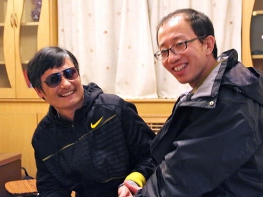 Aceasta fotografie nedatata il infatiseaza pe Hu Jia (d) un fervent critic al guvernului chinez intr-un moment mai destins alaturi de avocatul orb Chen Guangcheng dupa evadarea acestuia din urma, intr-o locatie nedezvaluita, in Beijing. (STR / AFP / GettyImages)