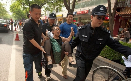 Un protestatar înlăturat de poliţie din spitalul Chaoyang din Beijing, unde se află internat activistul chinez orb Chen Guangcheng, care în prezent este tratat pentru o rană la picior, 4 mai 2012. Mulţi dintre cei care au dorit să-l viziteze pe Chen au fost arestaţi (AFP / GettyImages)