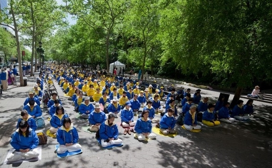 Sute de practicanţi Falun Dafa meditează în faţa clădirii ONU din New York, 13 mai 2012 (Epoch Times)