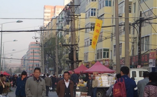 Un banner pe care scrie: "Adevăr, Compasiune, Toleranţă este bun", pe o stradă aglomerată. (minghui.org)