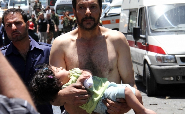 Un sirian cară corpul unei fetiţe rănită de explozia unui autobuz lângă Qudssaya, Damasc, 8 iunie 2012
