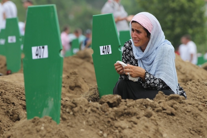 Femeie plângând la mormântul unui grup de 613 victime recent identificate - care au murit în timpul masacrului de la Srebrenica din 1995. 11 iulie 2011, cimitirul Potocari, Bosnia şi Herţegovina.
