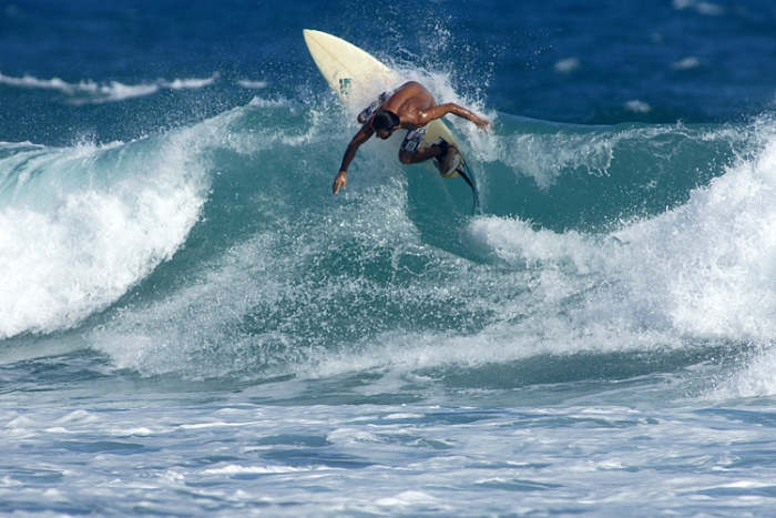 Surfeorul Jesmarin Puente călăreşte un val pe Encuentro Beach lângă Cabarete, Republica Dominicană.