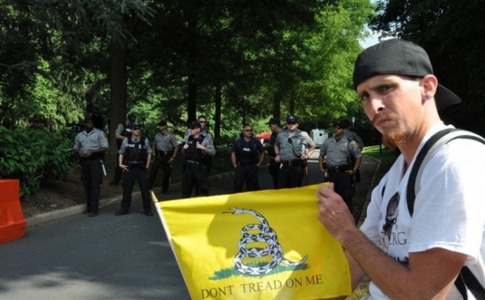 Personal de securitate şi protestatari în faţa clădirii unde se întâlesc membrii ezotericului Grup Bilderberg, Westfields Marriott în Chantilly, Virginia, 2 iunie. Grupul a ţinut întâlniri secrete de pe 31 mai până pe 3 iunie (Du Won Kang / The Epoch Times)