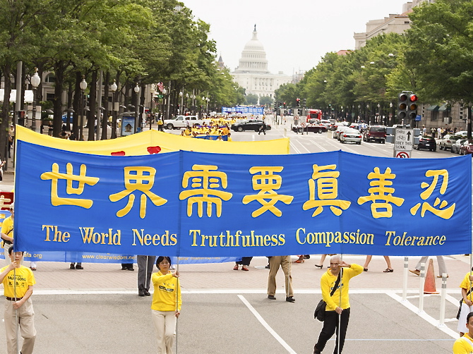 Practicanţii Falun Gong purtând bannere în parada din Washington, 13 iulie 2012, atrăgând atenţia asupra persecuţiei practicii ce continuă în China.