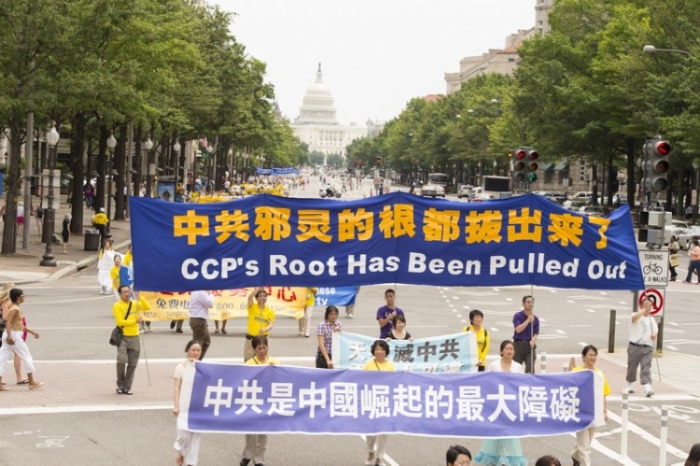 Practicanţii Falun Gong purtând bannere în parada din Washington, 13 iulie 2012.