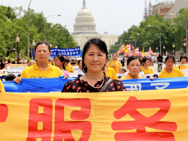 Rong Yi, preşedintele Centrului de Serviciu Global pentru Demisionarea din Partidul Comunist Chinez, printre bannerele paradei Falun Gong.