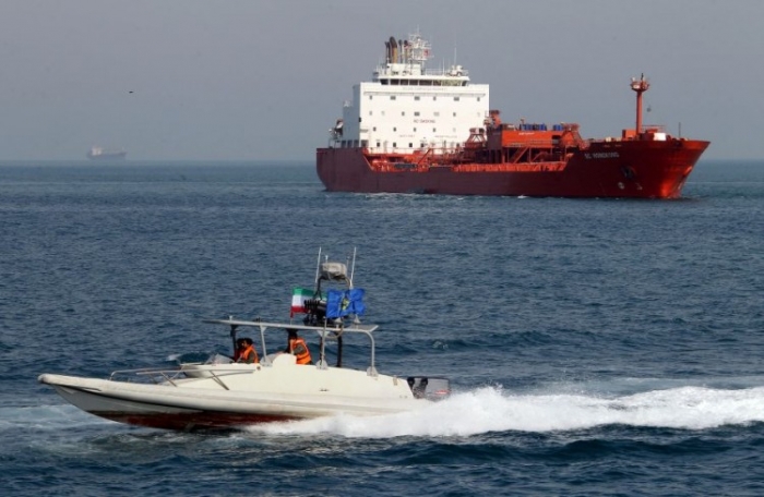 O şalupă rapidă a Gărzii Revoluţionare Iranieie trecând pe lângă o navă petrolieră aproape de portul Bandar Abbas, din sudul Iranului, 2 iulie.