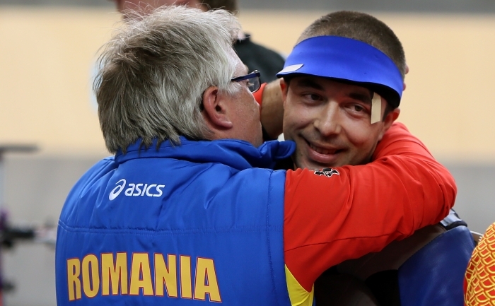 Românul Alin George Moldoveanu (dr) sărbătoreşte cu antrenorul lui după câştigarea medaliei de aur la tir pe 30 iulie 2012. (MARWAN NAAMANI / AFP / GettyImages)