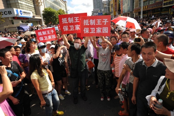 Protestatarii scandează lozinci şi ţin pancarde în faţa birourilor autorităţilor din Qidong, China. Protestele ar putea spori în zilele viitoare dacă vor veni şi cetăţenii care au promis online acest lucru.
