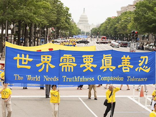 Practicanţii Falun Gong purtând bannere în parada din Washington, 13 iulie 2012, atrăgând atenţia asupra persecuţiei practicii ce continuă în China. (Dai Bing / The Epoch Times)