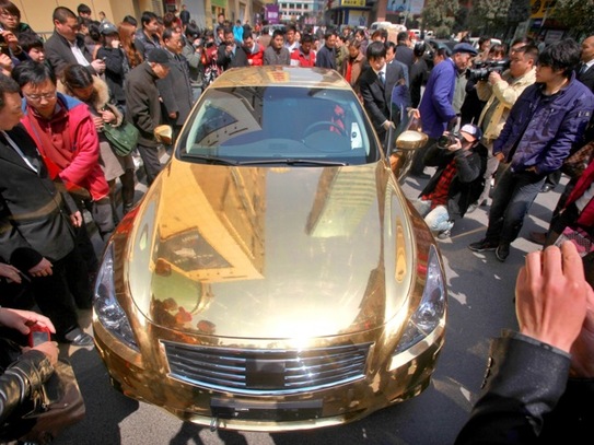 O maşină de lux Infiniti, aurită, într-un magazin de bijuterii din Nanjing, provincia Jiangsu 31 martie 2011. Oficiali de Partid corupţi şi plini de bani prezintă o problemă pentru Partidul Comunist Chinez, mulţi dintre ei fugind din ţară cu fonduri ilicite (STR / AFP / Getty Images)