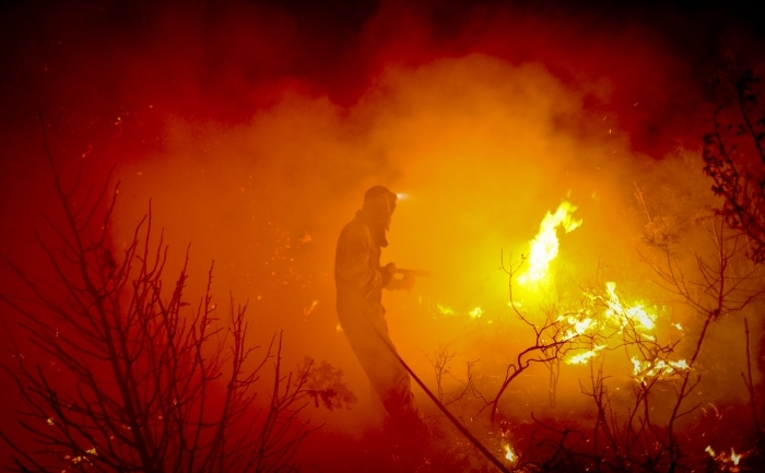 (Arhivă) Un pompier luptă cu focul în El cubillo de Uceda, în încercarea de a stinge un incendiu de pădure izbucnit lângă Guadalajara, Spania - 11 august 2012.