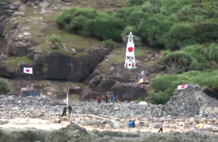 Naţionalişti japonezi plasând steagul Japoniei pe una dintre Insulele Senkaku Islands (Diaoyu) - 19 august 2012 (ANTOINE BOUTHIER / AFP / GettyImages)