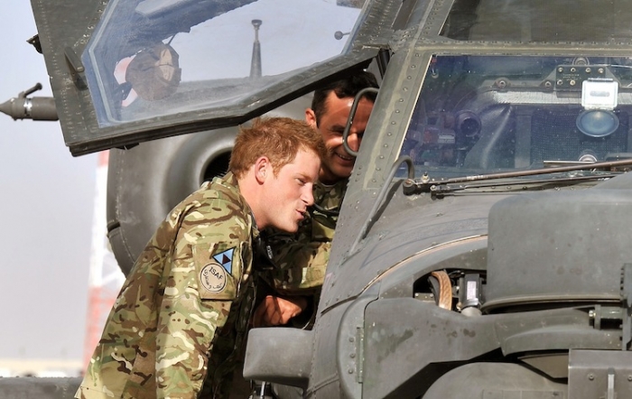 Prince Harry climbs up to examine the cockpit of an Apache helicopter with a member of his squadron (name not provided) on Sept. 7 at Camp Bastion, Afghanistan. Prince Harry has been redeployed to the region to pilot attack helicopters.