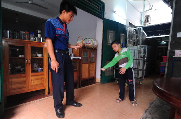 Huang Xiangyi (S) îl încurajează pe fiul său Huang Zhuoxiang, şapte ani, handicapat, 26 octombrie 2009, China