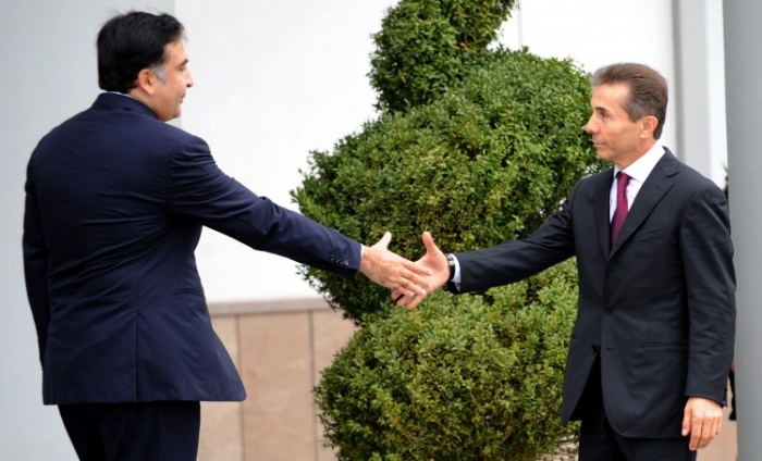 Preşedintele georgian Mihail Saakashvili, dând mâna cu noul premier Bidzina Ivanishvili, 9 otcombrie la Tibilisi