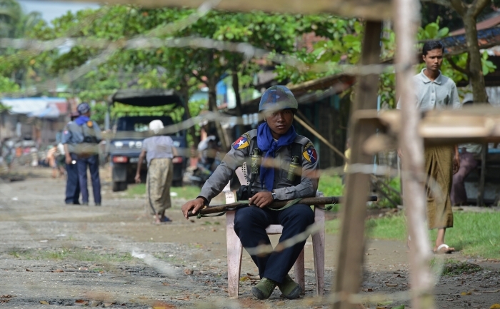 
Un poliţist stă în spatele unui gard din sârmă ghimpată ce blochează intrarea în cartierul Aung Mingalar, transformat într-un ghetou după ce violenţele au zguduit oraşul Sittwe, capitala statului vestic birmanez Rakhine, 13 octombrie 2012.