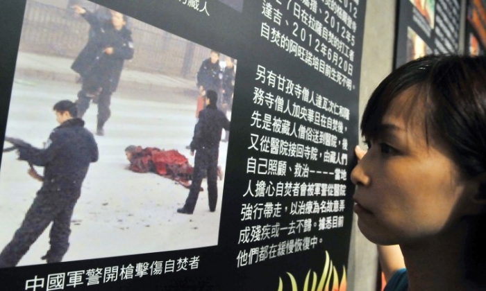 O tânără se uită la o fotografie în timpul unei prezentări a recentelor autoincendieri din Tibet – material realizat de filiala din Taiwan a organizaţiei Amnesty International, 29 iunie 2012. (Mandy Cheng / AFP / Getty Images)