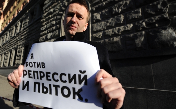 Alexei Navalny ţinând un banner pe care scrie "Sunt împotriva represiunii şi torturii" în timpul acţiunii sale personale.