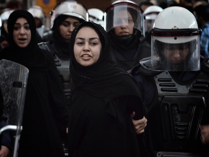O manifestantă şiită din Bahrain este reţinută de forţele de ordine în timpul unei demonstraţii antiguvernamentale în centrul capitalei, Manama, 21 septembrie 2012.