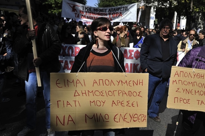 O jurnalistă grecoaică afişează o pancartă în timpul unei greve de 24 de ore în 18 octombrie 2011, Atena. Jurnaliştii greci vor intra in grevă din 6 până în 7 noiembrie după suspendarea din 30 octombrie 2012 a 3 jurnalişti eleni. (Louisa Gouliamaki / AFP / Getty Images)