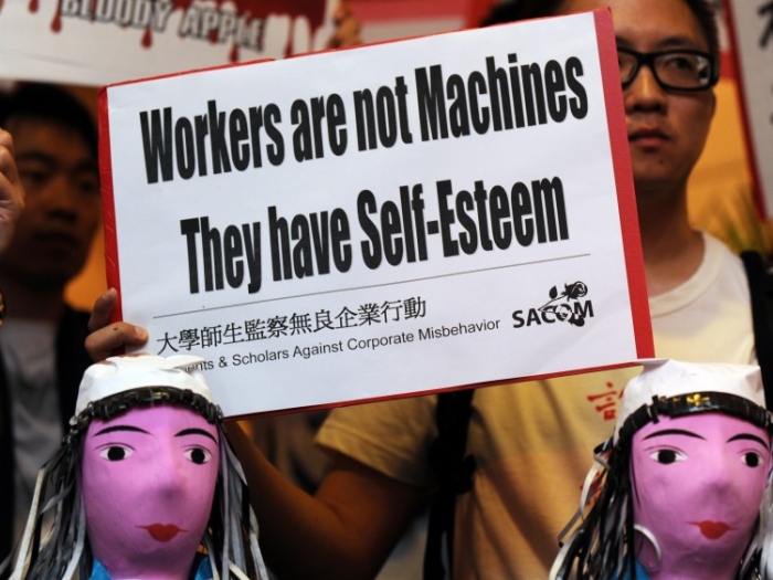 Studenţii protestează în timpul întâlnirii generale anuale a Foxconn în Hong Kong. Viaţa dificilă în gigantul electronicii au cauzat disperare în rândul muncitorilor săi şi mai multe sinucideri la fabrica Foxconn din China.