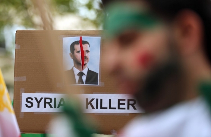Banner denunţându-l pe preşedintele sirian Bashar Assad, în timpul unui miting împotriva liderului iranian Mahmoud Ahmadinejad, în faţa sediului ONU, 26 septembrie 2012, New York (Mario Tama / Getty Images)
