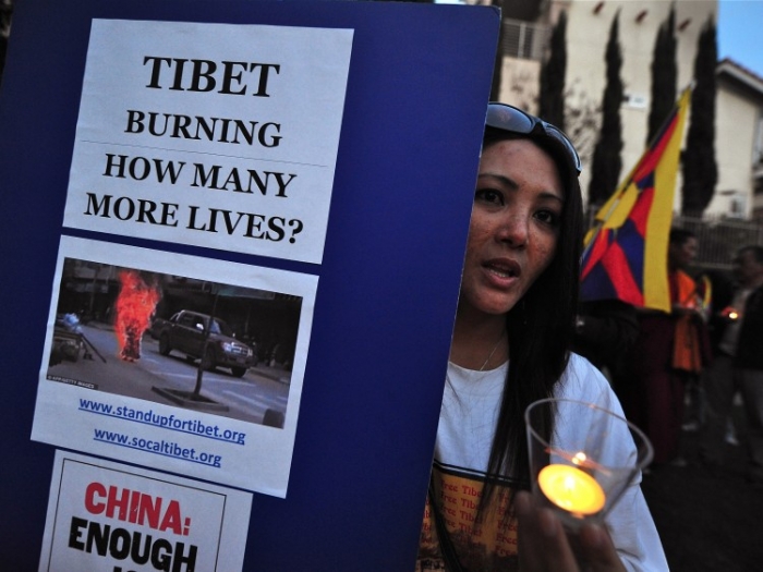 Tibetani şi susţinători ai mişcării ”Free Tibet” ţinând pancarte în timpul priveghiului cu lumânări în faţa Consulatului chinez din Los Angeles, 10 martie, 2012, California.