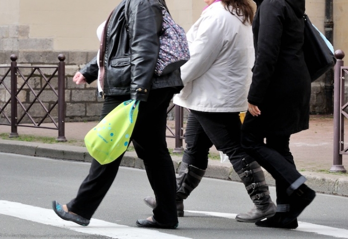O persoană supraponderală merge pe o stradă din oraşul nordic Lille.