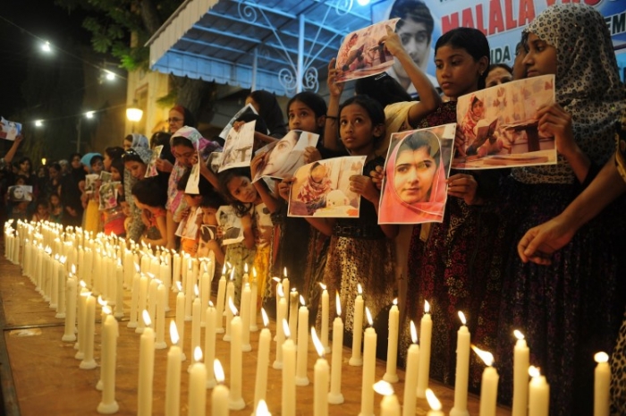 Susţinători pakistanezi ai Mişcării Muttahida Quami (MQM) afişează fotografii cu tânăra activistă Malala Yousafzai în timpul unui priveghi ce marchează Ziua Malala în Karachi, 10 noiembrie 2012.