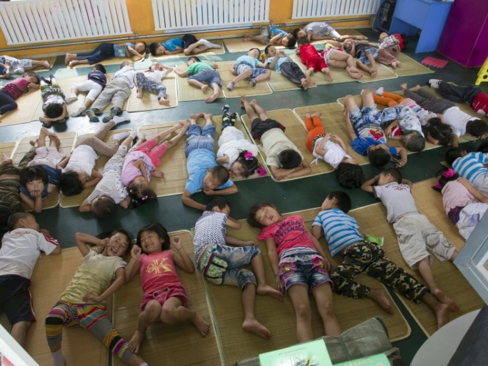 26 iunie 2012 - Copiii muncitorilor migratori se odihnesc într-o şcoală pentru emigranţi ilegali din Beijing care a primit ordinul să fie închisă, forţând copiii să se întoarcă acasă în provinciile lor. (STR / AFP / Getty Images)