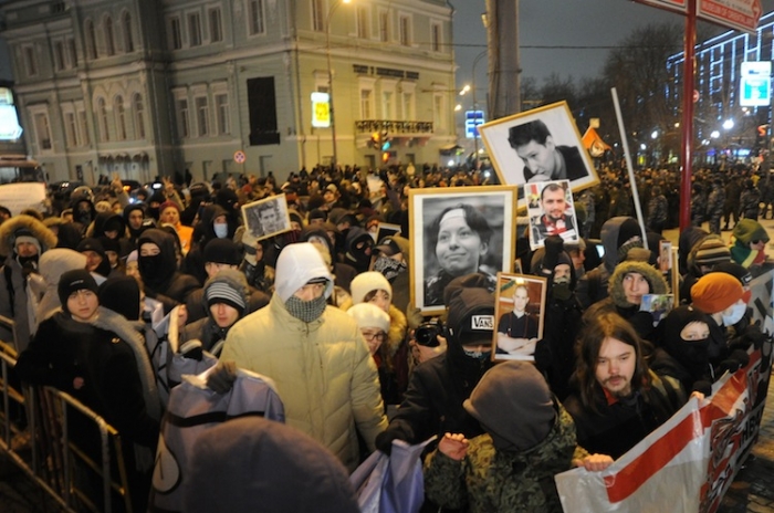 Demonstranţi ţinând portretul unui jurnalist asasinat la un miting în Piaţa Puşkinskaya, centrul Moscovei 19 ianuarie 2012 (Andrey Smirnov / AFP / Getty Images)