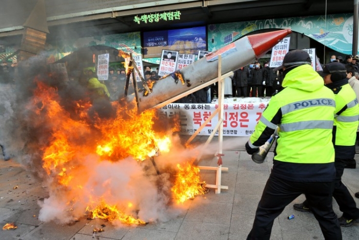 Poliţişti sud coreeni stingând foc în timpul unui miting ce denunţa lansările de rachete ale Coreei de Nord, Seoul 12 decembrie 2012.